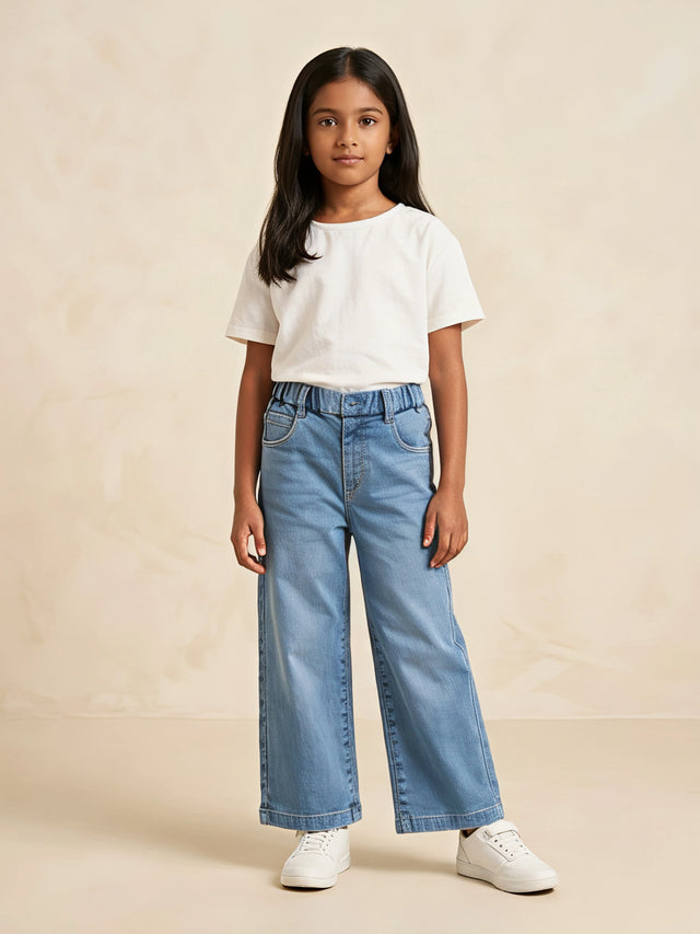 Young girl wearing light blue wide-leg casual pants paired with a white t-shirt and white sneakers