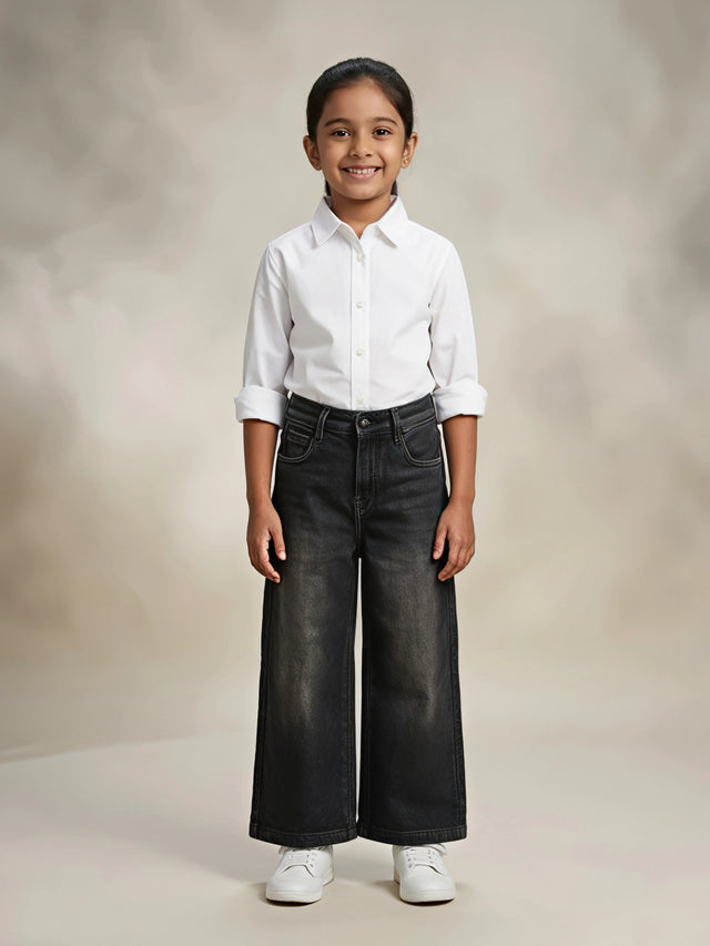 Young girl wearing stylish dark grey wide leg casual pants paired with a white button-down shirt and white sneakers.