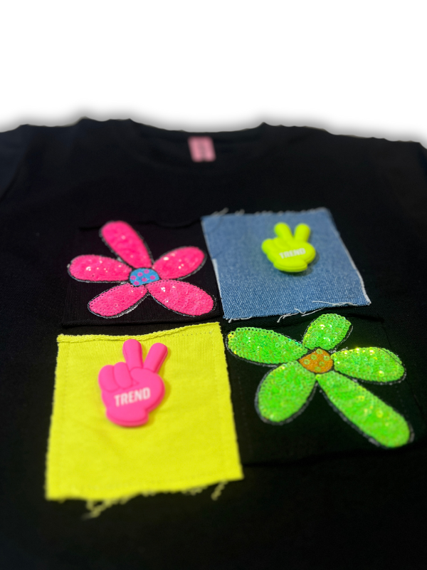 Girls' black long-sleeve top with four colorful patchwork squares and flower appliqués in neon pink, yellow, green, and blue on the chest.

Export to Sheets
