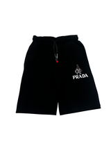 Black boys' matching coordinate set, including a short-sleeve T-shirt with a large metallic triangle logo and black shorts with a white logo graphic and drawstring