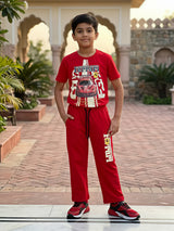 Young boy wearing a red Ferrari graphic t-shirt and matching red joggers coordinate set outdoors.