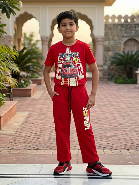Young boy wearing a red Ferrari graphic t-shirt and matching red joggers coordinate set outdoors.