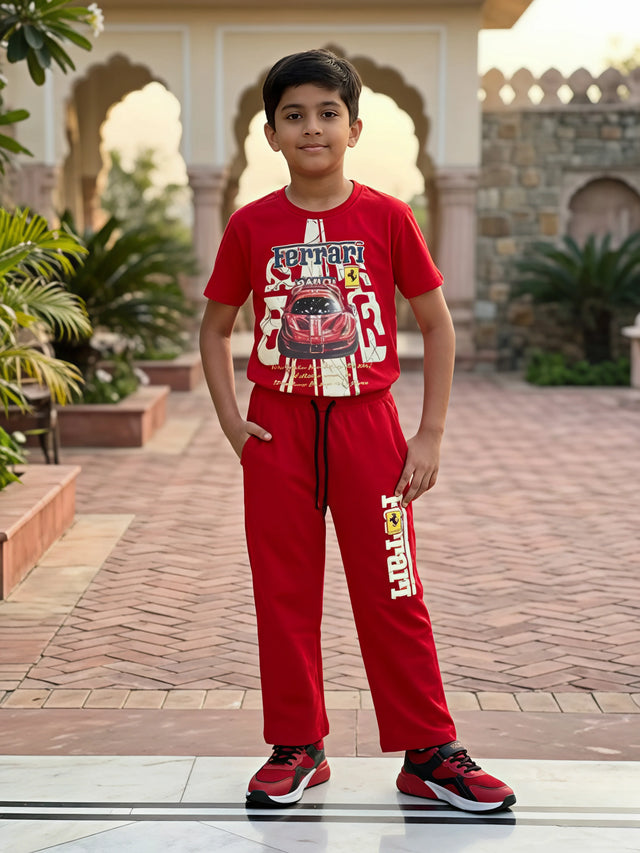 Young boy wearing a red Ferrari graphic t-shirt and matching red joggers coordinate set outdoors.