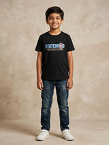A young boy wearing a black short-sleeve crew neck t-shirt with a blue and red graphic print reading 'STATEMENT' on the front, paired with blue jeans and white sneakers as seen in the file 8231-BLACK-RED SOUND-artguru.jpg.