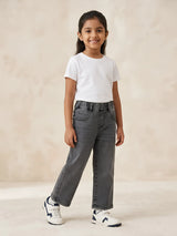 Young girl wearing stylish grey washed casual pants with an elastic waistband and front pockets paired with a white t-shirt.