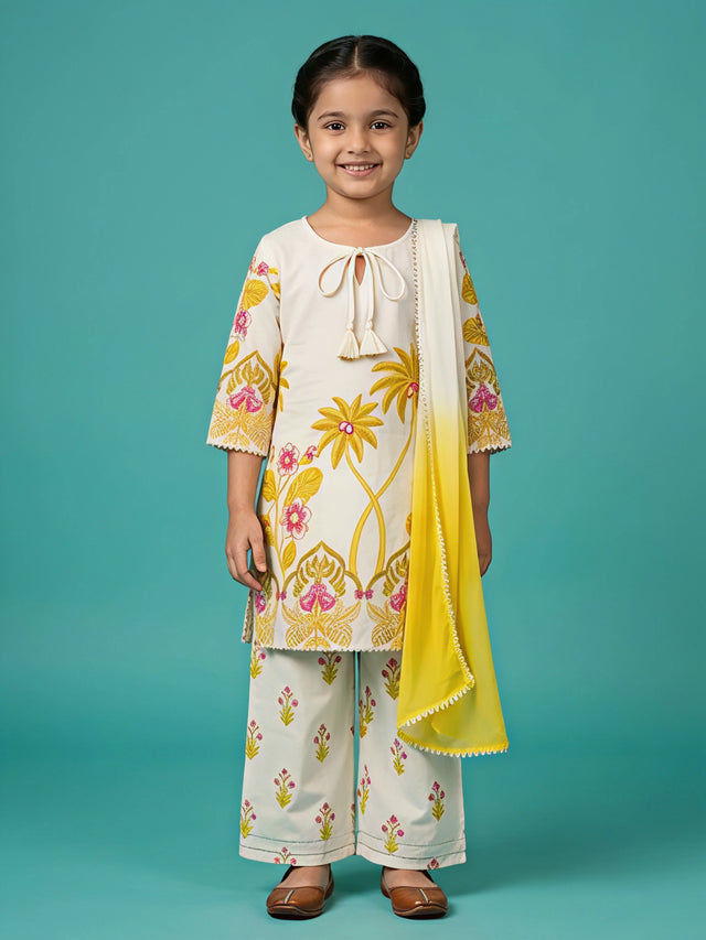 Young girl wearing an off-white and yellow floral printed kurta with matching palazzo pants and a yellow dupatta.