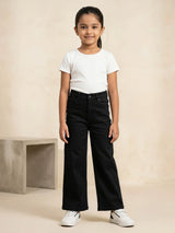 Young girl wearing black high-waisted wide-leg casual pants paired with a white t-shirt and white sneakers