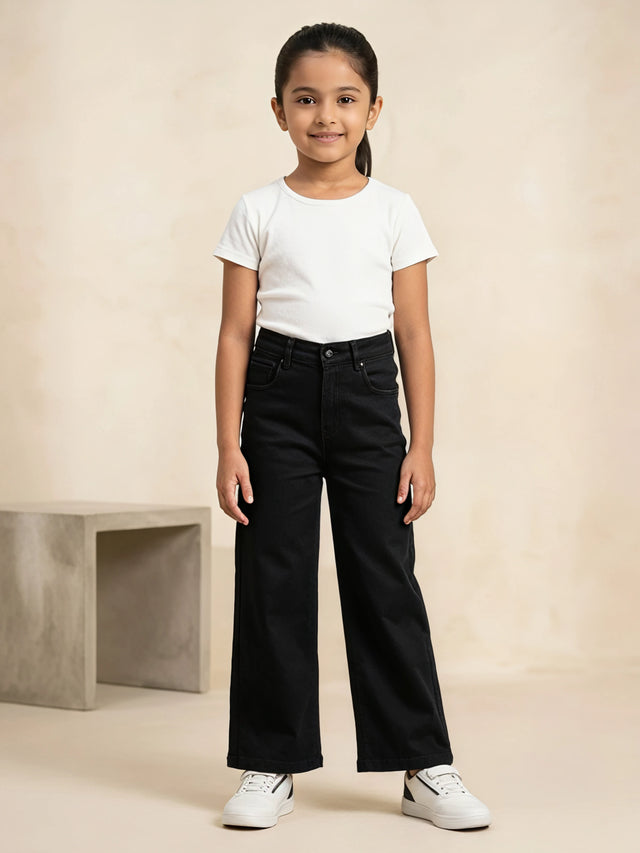 Young girl wearing black high-waisted wide-leg casual pants paired with a white t-shirt and white sneakers