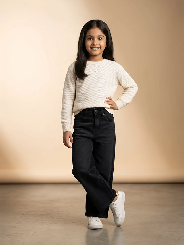 Young girl wearing stylish black wide-leg casual pants with a white sweater and sneakers