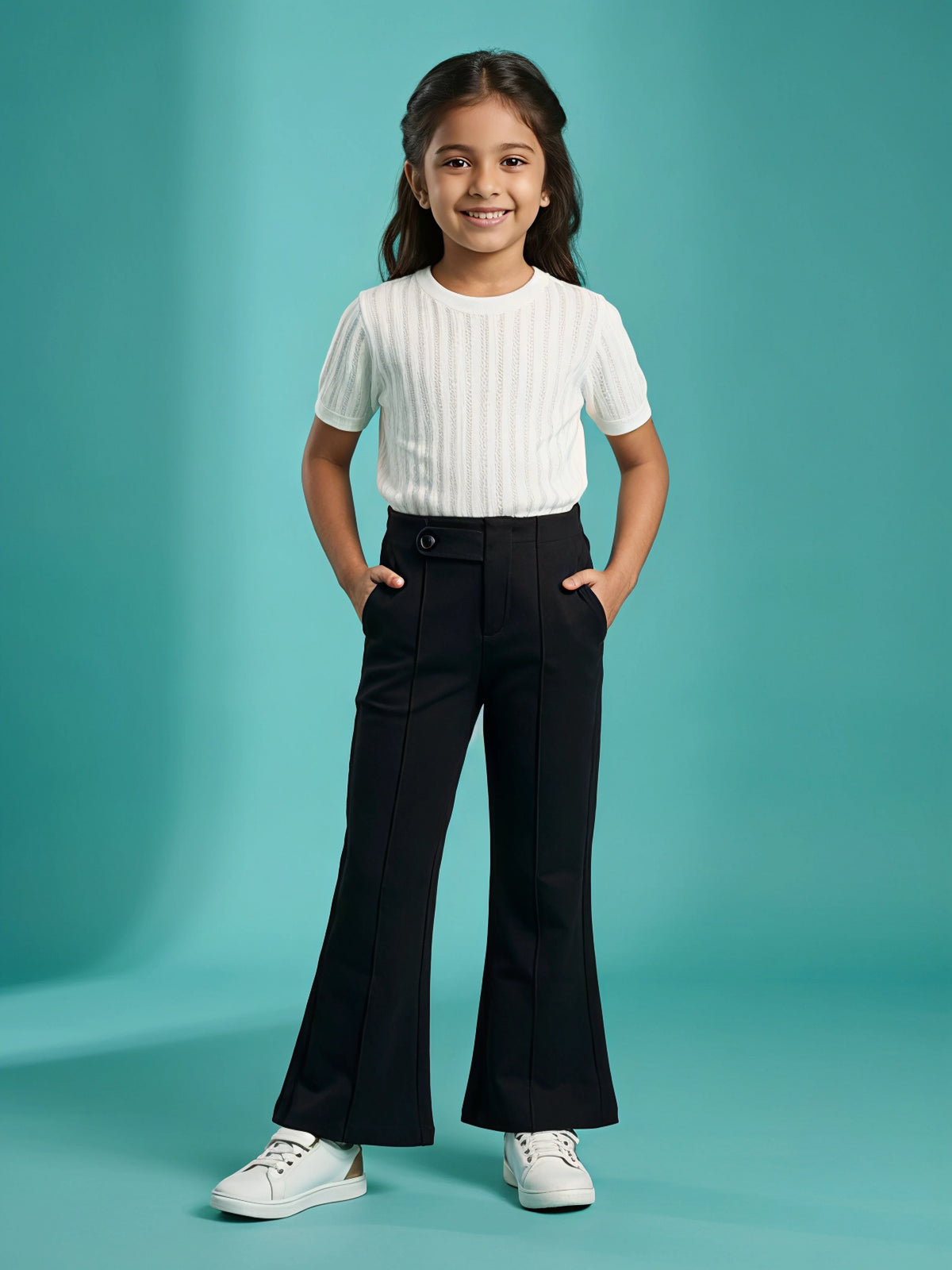 Young girl wearing stylish black high-waist flared casual pants with side pockets and a white top.