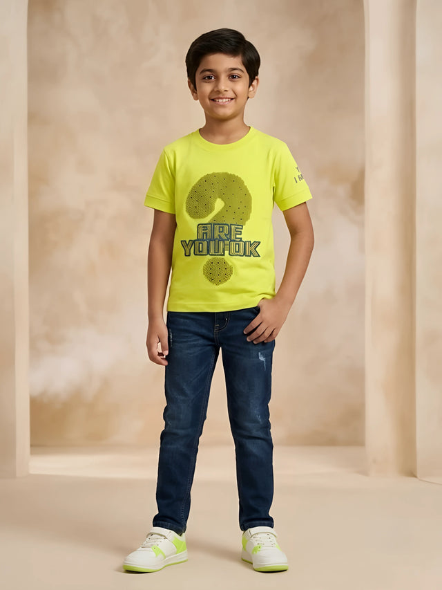 Boys wearing a neon green short sleeve graphic t-shirt with a question mark print paired with dark blue jeans