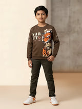 Young boy wearing a brown full sleeve Naruto graphic printed casual t-shirt with dark green pants and white sneakers