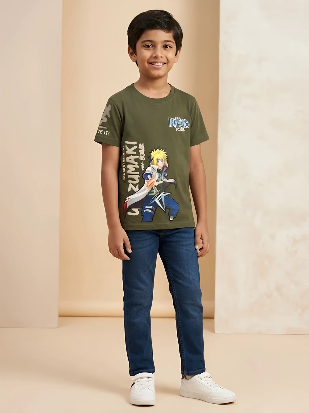 Young boy wearing an olive green anime graphic printed short-sleeve casual t-shirt with blue jeans