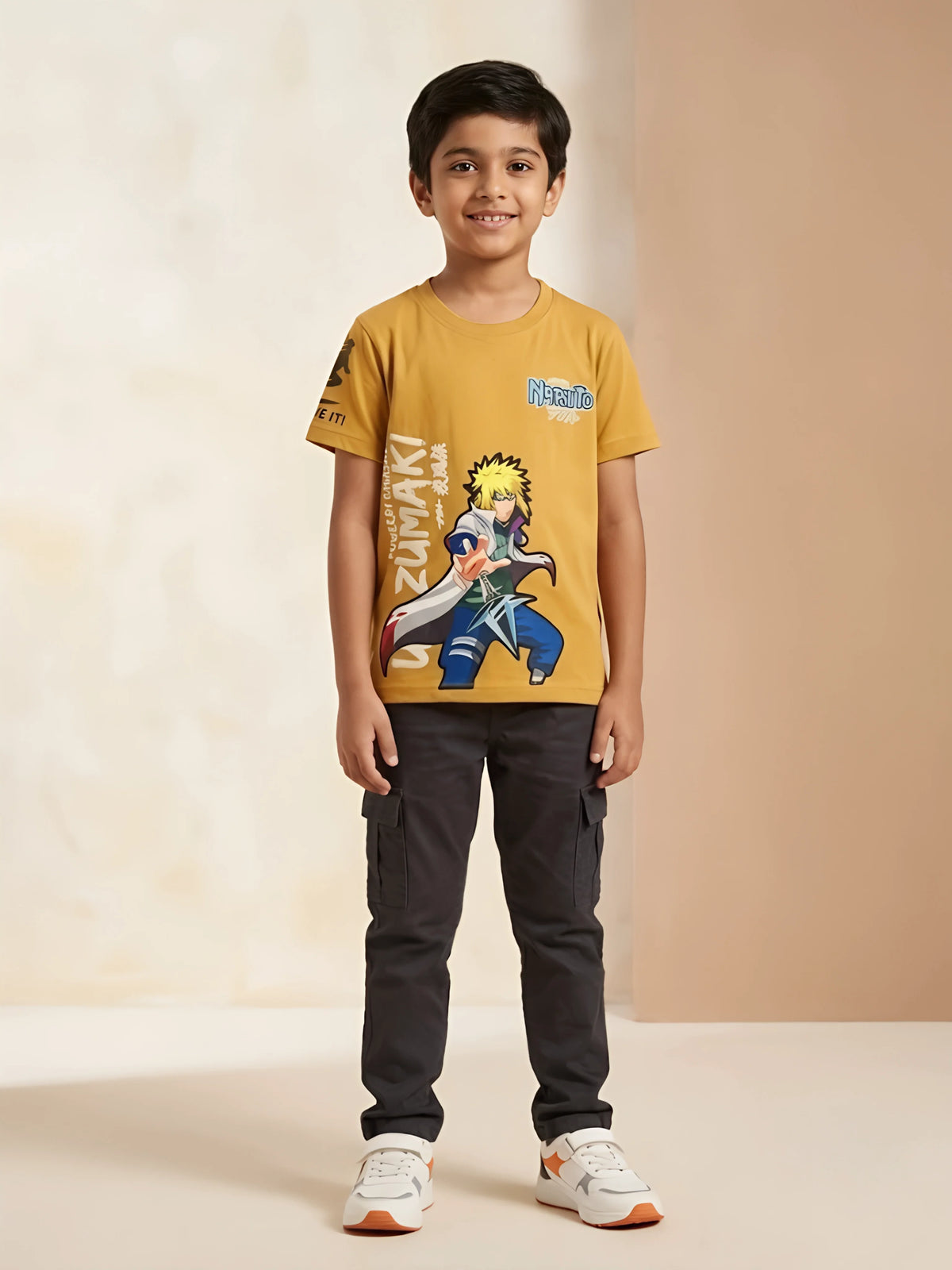 Young boy wearing a mustard yellow round-neck graphic printed anime t-shirt with short sleeves.