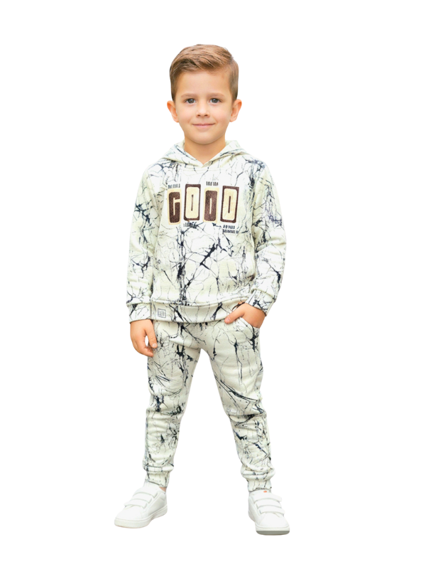 Full-length image of a young boy wearing a cream and black marble-printed hoodie and matching jogger pants coordinate set with a "GOOD" graphic on the chest, paired with white sneakers.