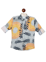 Boys' button-down shirt with a grey background and a bold, abstract print of orange circles and black leaves; sleeves are rolled up.