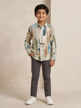 Young boy wearing a long-sleeve green abstract printed casual shirt paired with dark trousers