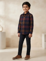 Boys wearing a brown and navy plaid full sleeve casual shirt with black trousers