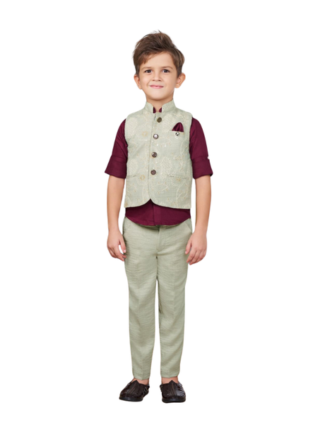 Full-length image of a young boy wearing a three-piece formal set: a light sage green embroidered waistcoat over a maroon short-sleeve shirt, and matching sage green trousers.