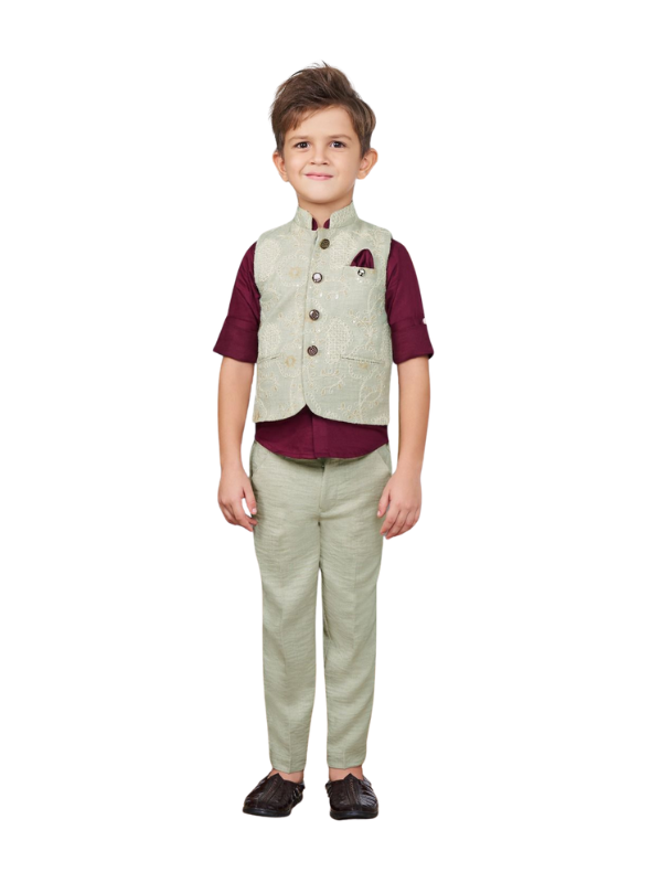 Full-length image of a young boy wearing a three-piece formal set: a light sage green embroidered waistcoat over a maroon short-sleeve shirt, and matching sage green trousers.