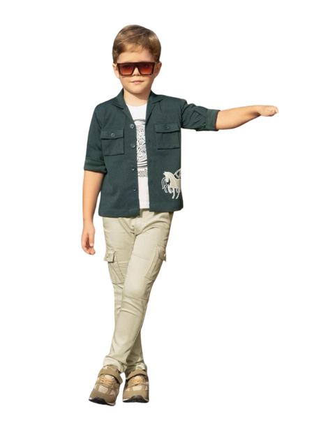 Young boy posing in a dark forest green short-sleeve utility shirt jacket, layered over a white t-shirt with a horse graphic, and paired with khaki cargo trousers and sneakers.