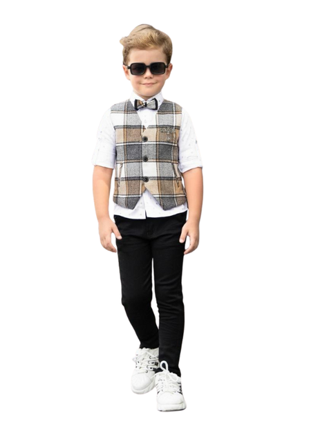 Young boy posing in a white long-sleeve shirt with sleeves rolled, a brown and cream plaid waistcoat, black trousers, a matching bow tie, and white sneakers.