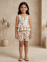 Young girl wearing a cream co-ord set with peach and teal floral prints, featuring a ruffled sleeveless top and matching shorts