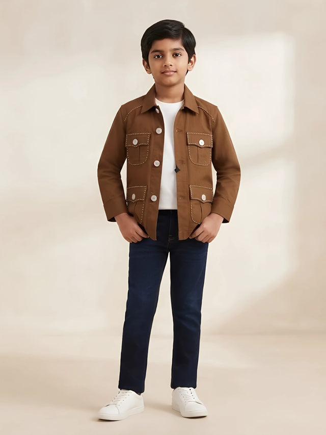Boy wearing a brown full sleeve casual shirt with front flap pockets and contrast stitching