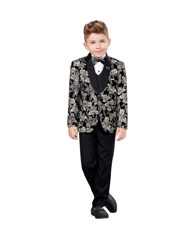 Young boy posing in a black suit set featuring a slim-fit black and cream floral patterned blazer, black vest, black trousers, and a black bow tie over a white shirt.