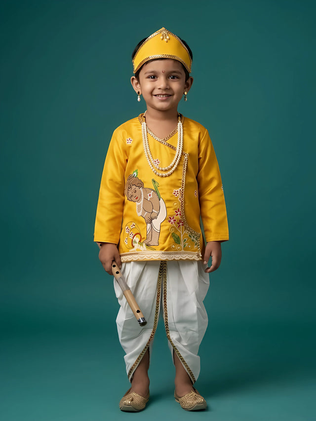 Young boy wearing a bright yellow Kanha angrakha kurta with Krishna illustration and off-white dhoti set with golden border and matching headband