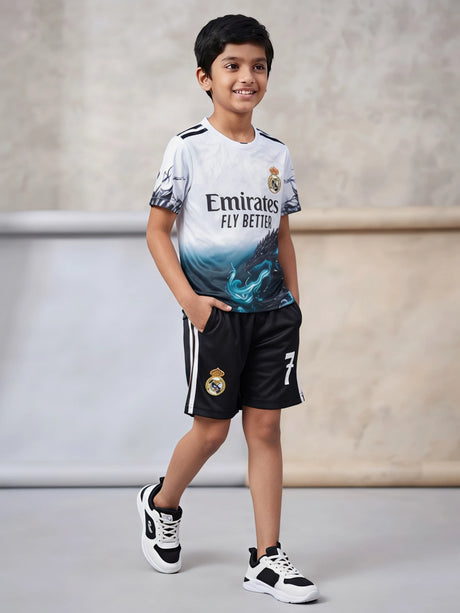 Young boy wearing a white and black sports co-ord set with graphic print t-shirt and matching striped shorts.