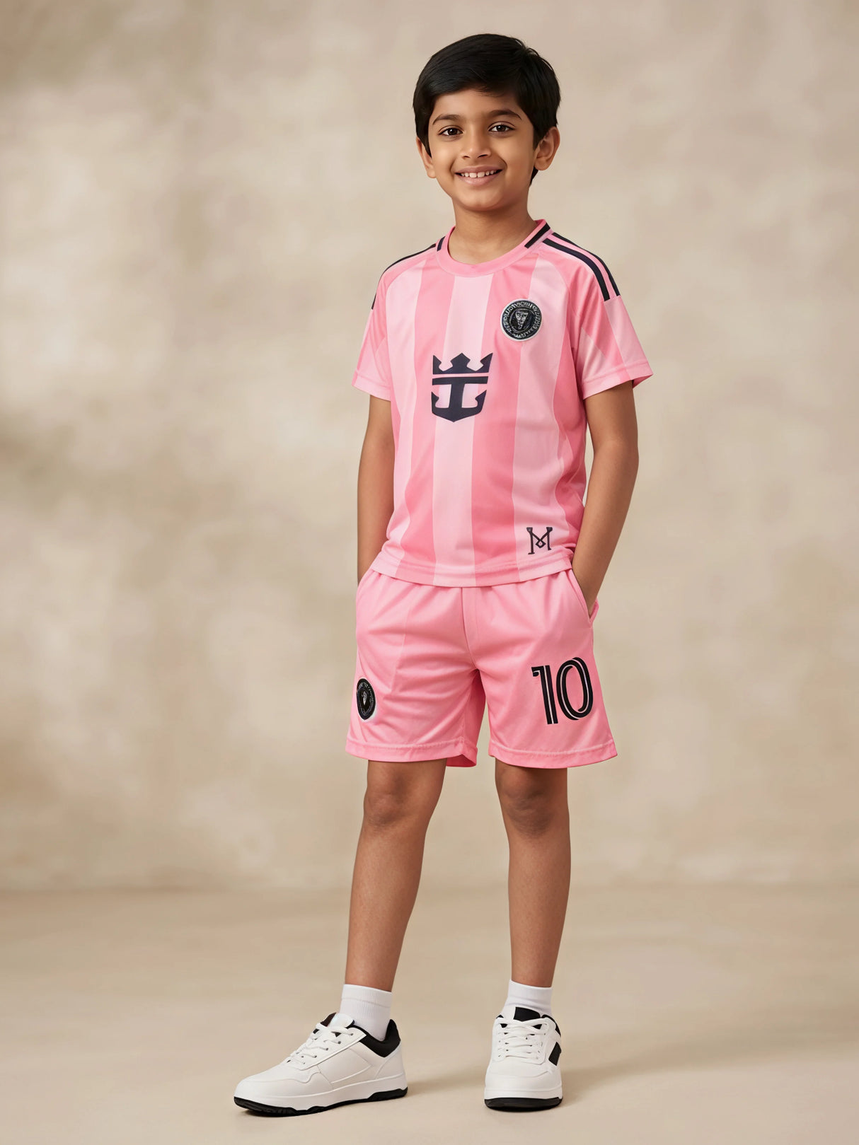 Young boy wearing a stylish peach sports coordinate set with a striped short-sleeve t-shirt and matching shorts with pockets.