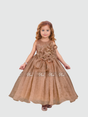 Young girl smiling in a full-length, voluminous rose gold/bronze shimmering party gown. The dress features a large, ruffled 3D flower appliqué on the bodice and a small matching bow at the waist