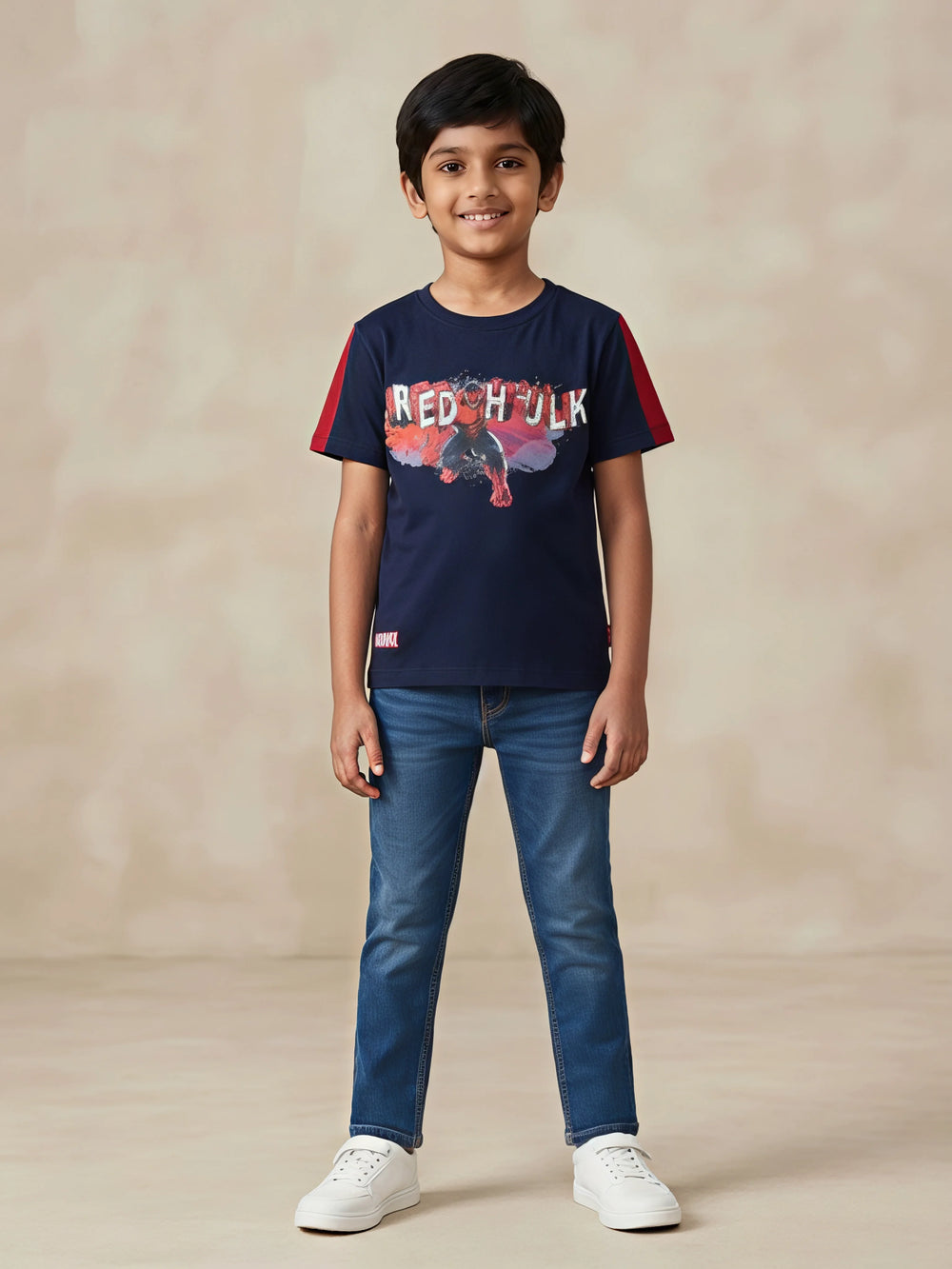 Young boy wearing a navy blue round neck t-shirt with Marvel Red Hulk chest print and red sleeve panels.