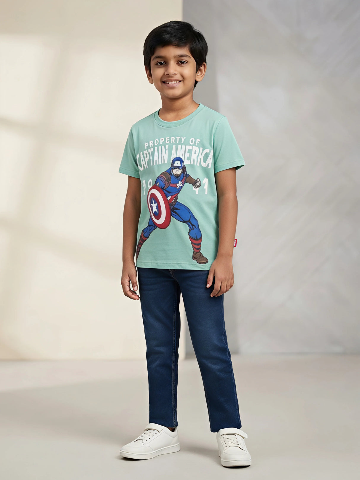 Young boy wearing a sea green short sleeve t-shirt with Captain America graphic print paired with blue jeans