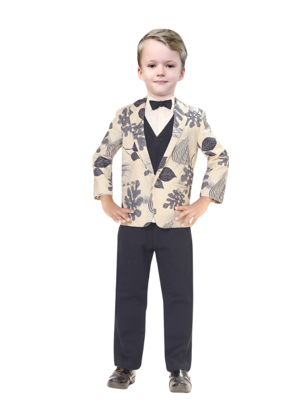 Full-length image of a young boy wearing a three-piece suit: a cream and black leaf-print blazer over a black vest and trousers, accessorized with a black bow tie.