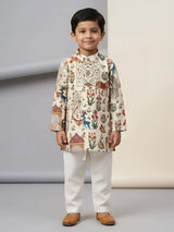 Young boy wearing cream floral and animal printed kurta with off-white pyjama trousers and tan juttis