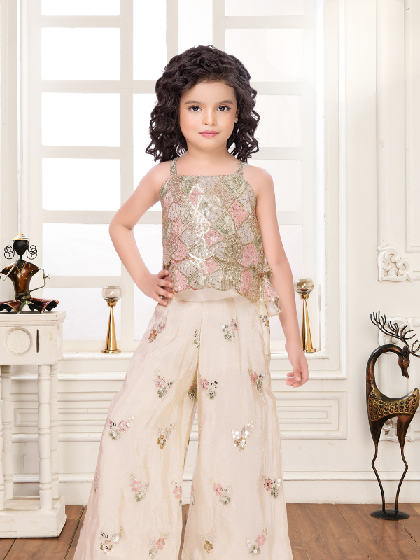 Young girl wearing a beautiful cream three-piece lehenga set with a flared skirt, sleeveless crop top, and embroidered open jacket, all featuring colorful pastel floral embroidery.