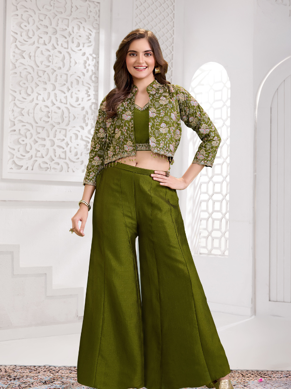 Woman posing in a three-piece olive green ethnic outfit consisting of a crop top, wide-leg palazzo pants, and a heavily embroidered short jacket with three-quarter sleeves.