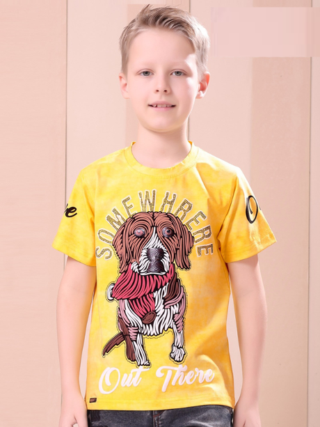 Young boy smiling and modeling a bright yellow T-shirt with a large, stylized brown and white dog graphic and the text 'Somewhere Out There.'