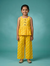 Young girl wearing a vibrant yellow sleeveless peplum top and matching striped plazo pants set