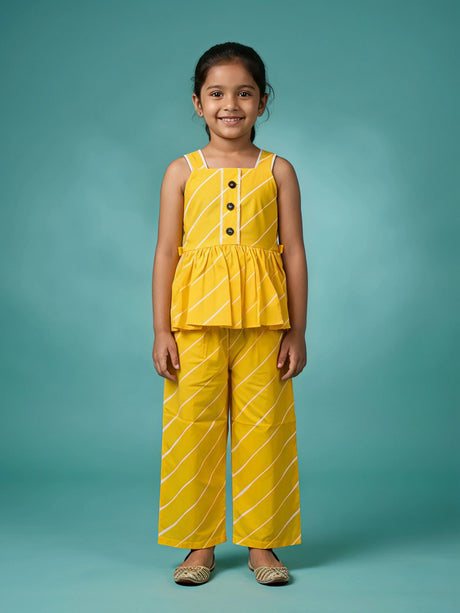 Young girl wearing a vibrant yellow sleeveless peplum top and matching striped plazo pants set