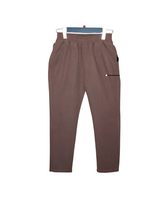 Front view of dark brown boys' casual trousers with an elastic waistband and a decorative white-dotted zipper pocket on the side, hanging on a hanger.