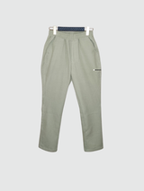 Light sage green boys' muslin cotton pants with a relaxed, tapered fit, elasticated waist, and a small horizontal zipper detail on the hip