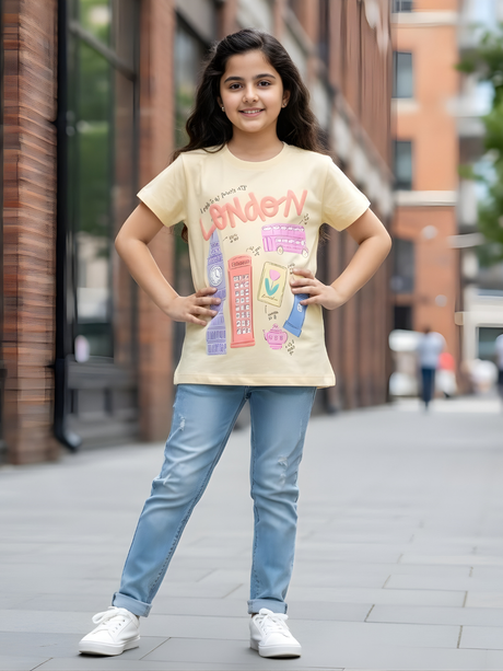 Young girl wearing an orange short-sleeve t-shirt with a London landmarks graphic including Big Ben and a bus.