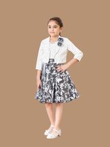 White sheer organza girls' frock hanging on a hanger, featuring blue, yellow, and green floral stem appliqués and a matching white tie-up belt with tassels.