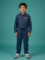 Young boy wearing a navy blue long-sleeve embroidered shirt and matching drawstring trousers co-ord set