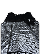 Black and white patterned girls' handkerchief hem frock with a black velvet-look bow and pearl trim on a white background.

Export to Sheets