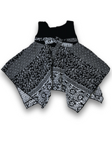 Black and white patterned girls' handkerchief hem frock with a black velvet-look bow and pearl trim on a white background.

Export to Sheets