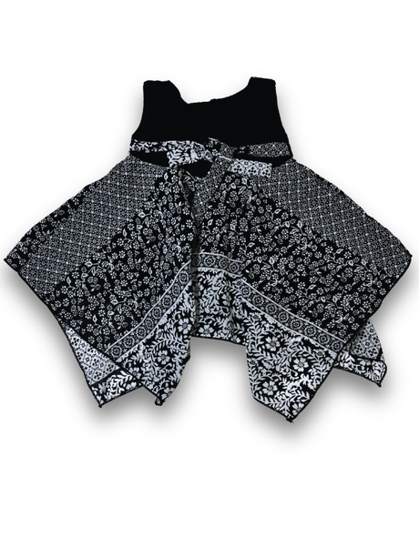 Black and white patterned girls' handkerchief hem frock with a black velvet-look bow and pearl trim on a white background.

Export to Sheets